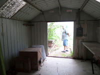 Paved floor of more shed off the back. greenhouse is behind.