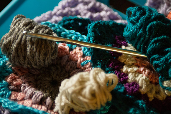 Crochet yarn and hook with balls of yarn and granny square