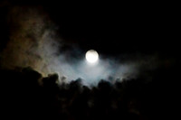 Full moon with colorful clouds rising from below