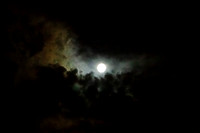 Full moon with colorful clouds rising from below