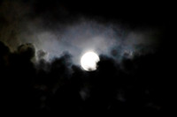 Full moon with colorful clouds rising from below