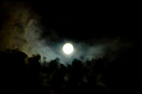 Full moon with colorful clouds rising from below