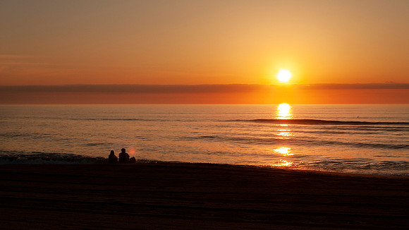 Couple watches the sunrise over the sea