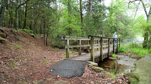 A woman walks across a footbridge