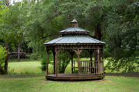 Gazebo in a park with green trees and grass