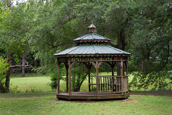 Gazebo in a park with green trees and grass
