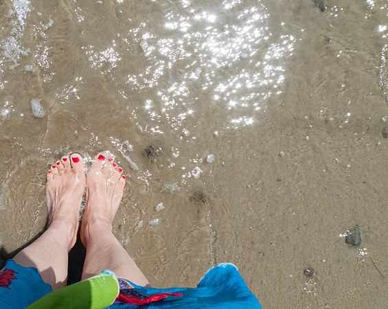 Earthing at the beach with bare feet in the wet sand